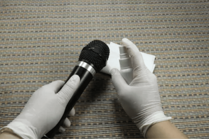 Cleaning a handheld microphone with latex gloves