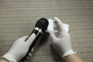 Sanitizing a mic with latex gloves and cleaning solution